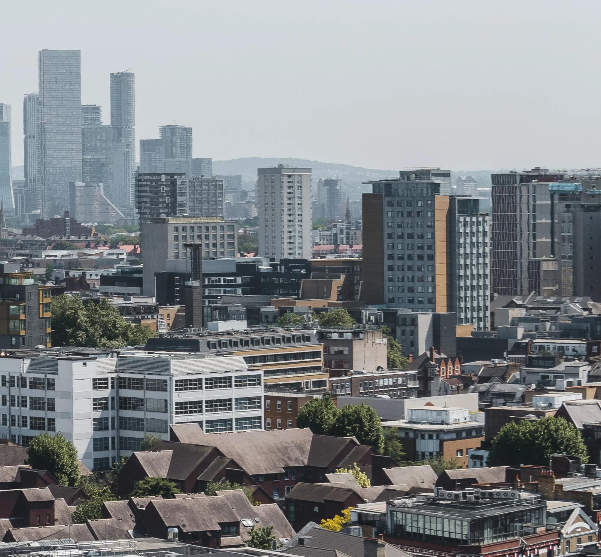 London rooftops and towers under haze, seen from above.