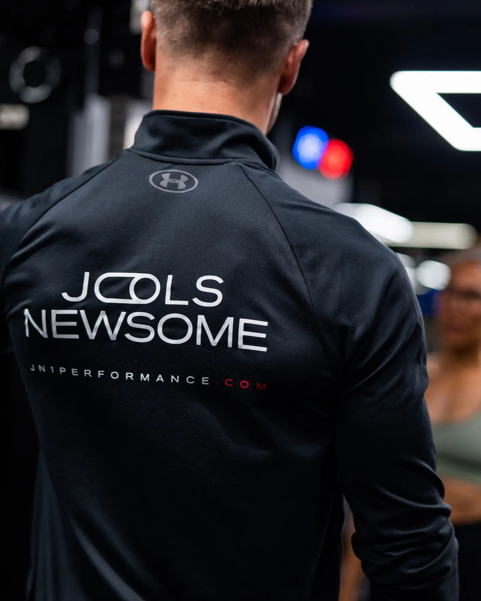 Jools Newsome in a coaching session at UNTIL, his wordmark across the back of his training top.